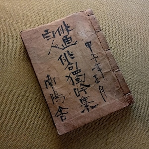 Puede incluir: Un libro rectangular vintage con una cubierta marr&oacute;n desgastada. Caligraf&iacute;a negra cubre la portada, con el t&iacute;tulo y el nombre del autor visibles. El libro est&aacute; encuadernado con un hilo visible a lo largo del lomo.