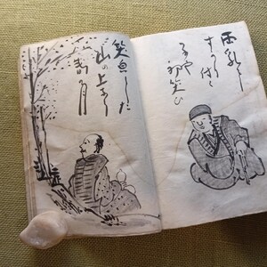 Puede incluir: Un libro abierto con caligraf&iacute;a japonesa e ilustraciones a tinta de figuras y &aacute;rboles. Las p&aacute;ginas est&aacute;n envejecidas, con un tono beige claro. Las ilustraciones son en tinta negra, representando escenas de personas y naturaleza.