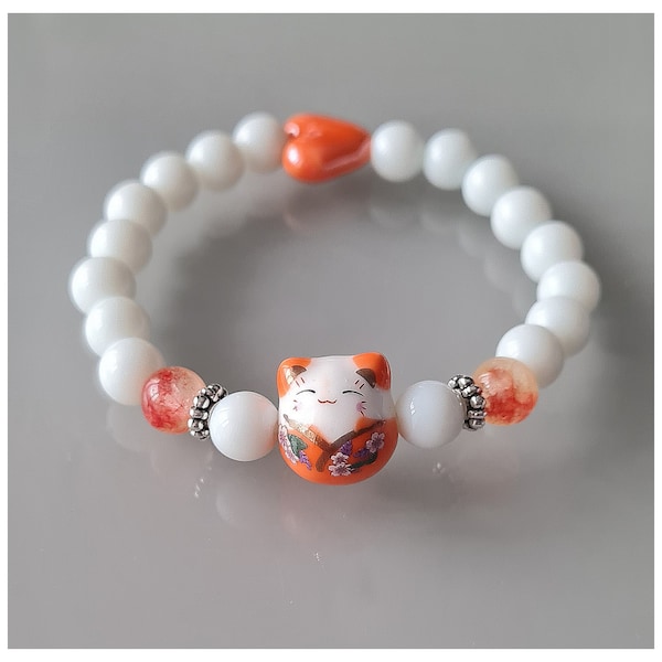 Bracelet chat porte bonheur Maneki-neko orange. Perles en jade blanc et orange, coeur en céramique et chat en porcelaine. Pièce unique.