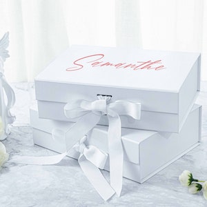 May include: Two white gift boxes with a white satin ribbon bow. The top box has the name "Samantha" printed on it in pink lettering.