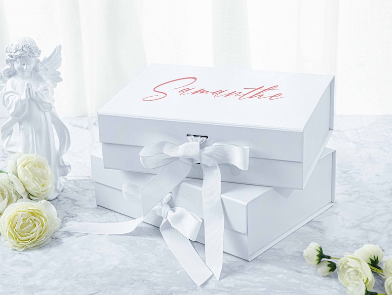 May include: Two white gift boxes with a white satin ribbon bow. The top box has the name "Samantha" printed on it in pink lettering.