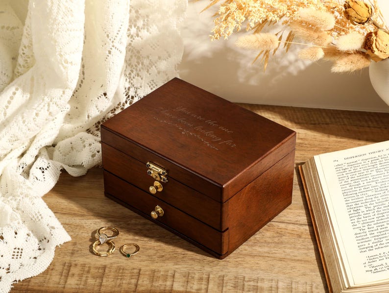 May include: A dark brown wooden jewellery box with two drawers and a hinged lid. The lid has the inscription "You are the one I have been looking for".