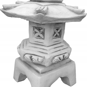 Puede incluir: Linterna de pagoda de hormig&oacute;n blanco con una base cuadrada y un techo decorativo. La linterna tiene tallas intrincadas y un dise&ntilde;o asi&aacute;tico tradicional.