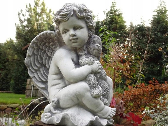 Enfant d'ange avec la statue de pierre de jouet, figure concrète d