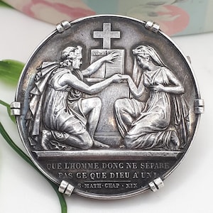 Por tanto, que no separe el hombre lo que Dios ha unido. Soberbia medalla de plata o prenda nupcial montada en un broche.