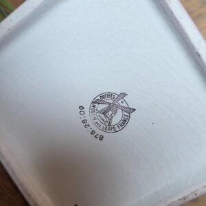 Op de afbeelding: Witte keramische plantenbak met een zwart-wit logo met de tekst "Moulin des Loups - Orchies - France" en "878.28.00".
