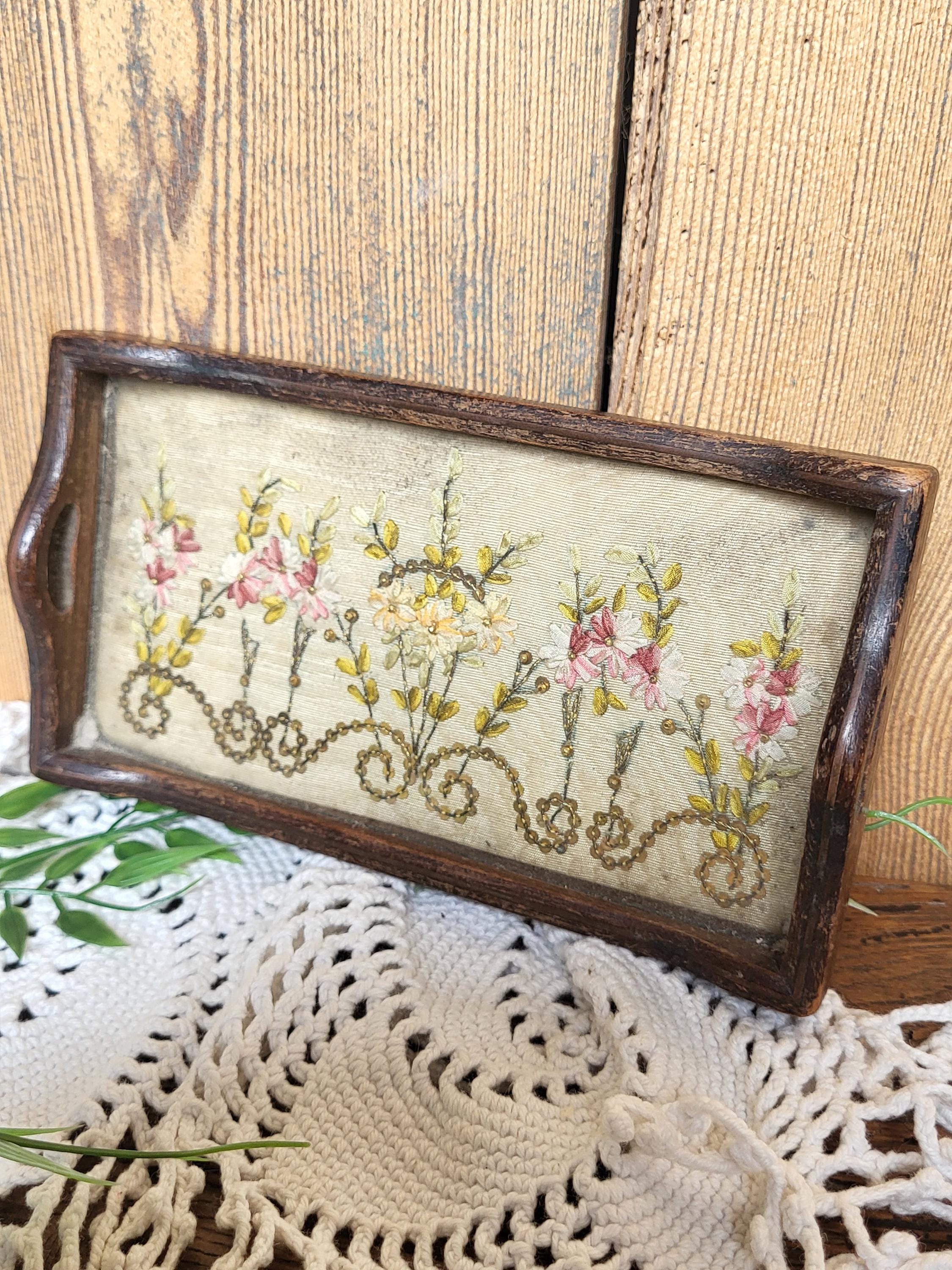 刺繍された花が入った古い小さな木製トレイ。北フランスの刺繍