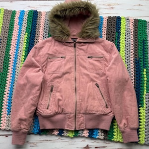 May include: A pink corduroy jacket with a faux fur lined hood. The jacket has a zipper closure and two pockets on the front.