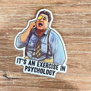 May include: A sticker featuring a cartoon character with a yellow eye patch, wearing a blue shirt, a patterned tie, and suspenders. The text "IT'S AN EXERCISE IN PSYCHOLOGY" is below the character.