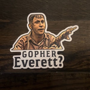 May include: A sticker featuring a cartoon illustration of a man with a surprised expression, pointing to the right. The text "Gopher Everett?" is printed below the image.