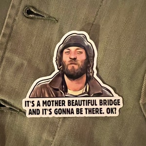 May include: A sticker featuring a man with a beard and a hat, with the text "It's a mother beautiful bridge and it's gonna be there. Ok?"