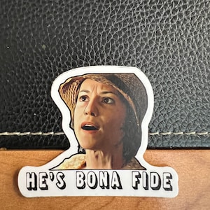 May include: A white sticker with a woman in a straw hat and the text "He's Bona Fide" in black letters.