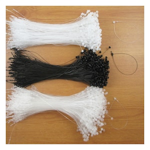 May include: A bundle of white, black and clear plastic string ties. The ties are bundled together and have a small plastic loop at the end.