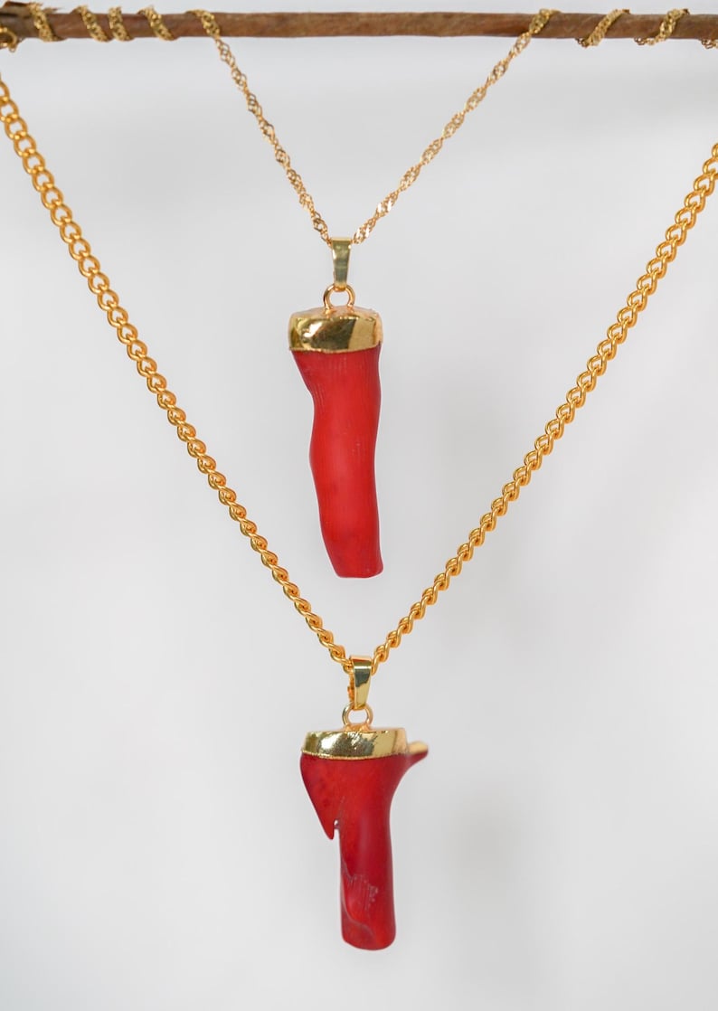 May include: Two gold chains with red coral pendants. The coral is a natural, organic shape.