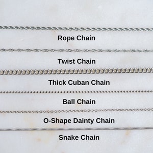 May include: A close-up of six different types of silver chains: rope, twist, thick Cuban, ball, O-shape dainty, and snake.