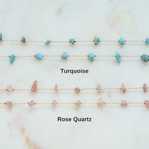 May include: Two gold chains with turquoise and rose quartz stones. The top chain has turquoise stones and the bottom chain has rose quartz stones.