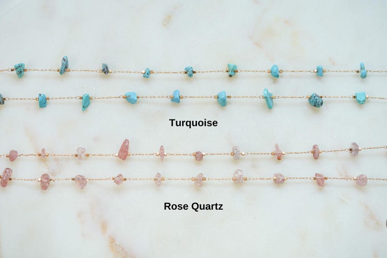 May include: Two gold chains with turquoise and rose quartz stones. The top chain has turquoise stones and the bottom chain has rose quartz stones.