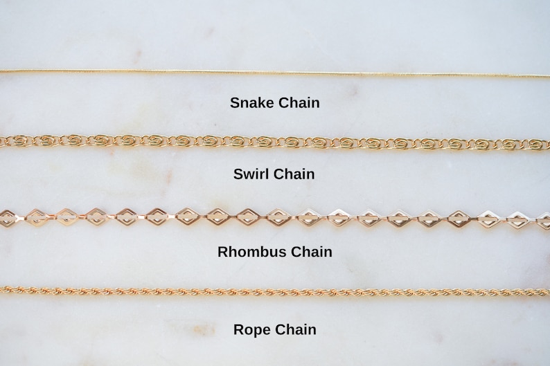 May include: Four different types of gold chains are displayed on a white marble surface. The chains are labeled "Snake Chain", "Swirl Chain", "Rhombus Chain", and "Rope Chain".