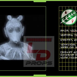 May include: A digital display showing a Rodian character with a mask and large eyes. The display includes text and a graphic of a symbol with a red drop and a green leaf. The text reads "LD PROPS".