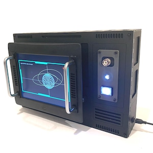 May include: A black, retro-style electronic device with a screen displaying a blue and white graphic. The device has a handle, a power button, and a port. The screen shows a spherical design with lines. The device has a USB cable.