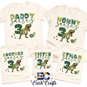May include: Cream-colored t-shirts and a onesie with dinosaur-themed graphics. The shirts read "Daddy Saurus," "Mommy Saurus," "Brother Saurus," "Sister Saurus," and "Ethan Saurus," each with a number 3 and a T-Rex illustration.