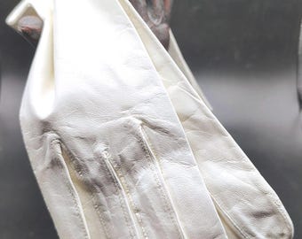 May include: A pair of white gloves featuring a smooth, textured surface with visible stitching along the fingers and a tapered wrist opening. The gloves are crafted with a soft finish and display natural creases throughout the material.