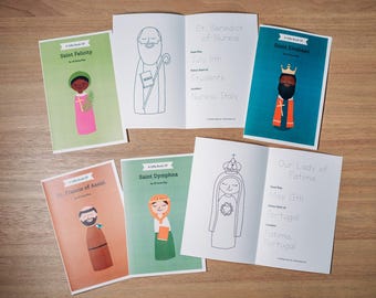 May include: A collection of small, illustrated books on a wooden surface. The covers feature colorful illustrations of saints, with titles like "Saint Felicity" and "Saint Dymphna." Open books display line drawings and text about the saints.