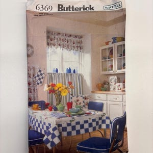 May include: A Butterick 6369 Waverly sewing pattern envelope featuring a kitchen scene with a blue and white checkered tablecloth, blue chairs, a floral valance, and various kitchen accessories. The paper envelope shows text 6369 Butterick.
