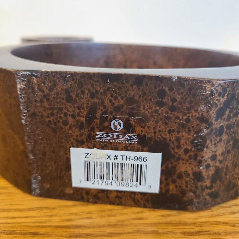 Op de afbeelding: Een bruine, zeshoekige decoratieve kom met een gespikkeld patroon. De kom heeft een sticker met de tekst "ZODAX MADE IN THAILAND" en een productcode "TH-966".
