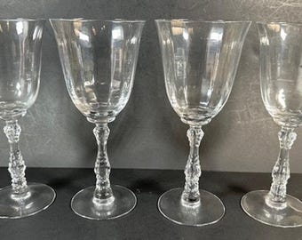 May include: Set of four clear glass wine glasses with a fluted design and a textured stem.