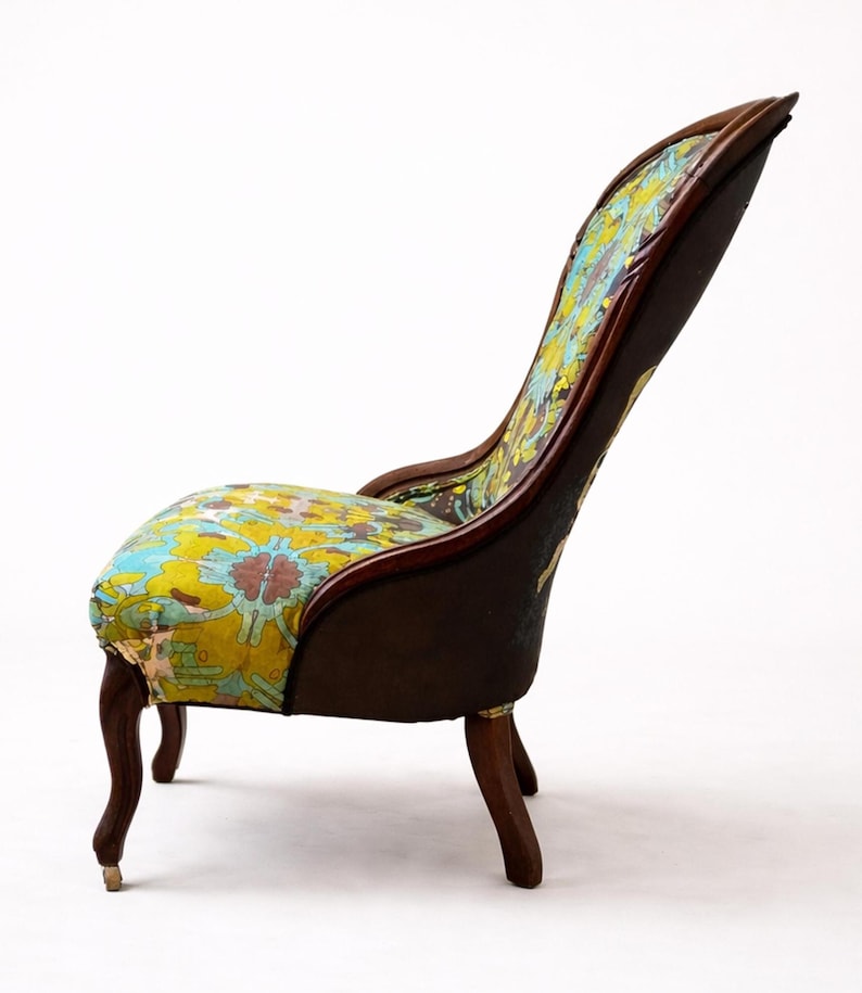Pu&ograve; includere: Sedia antica con schienale alto e struttura in legno curvata. La seduta e lo schienale sono rivestiti con un colorato motivo floreale nei toni del giallo, blu e rosso. La sedia ha quattro gambe curve.
