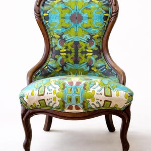 Pu&ograve; includere: Sedia antica in legno con seduta e schienale in tessuto fantasia. Il tessuto presenta un design colorato nelle tonalit&agrave; del blu, verde e marrone. La sedia ha gambe curve e finitura in legno scuro.