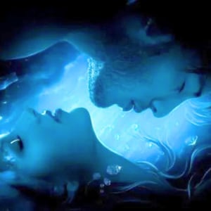 May include: A digital illustration featuring two faces in profile, positioned facing each other in a deep blue, aquatic environment. The scene is illuminated by a bright, glowing light source between them, with small air bubbles floating around.