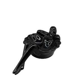 Könnte beinhalten: Schwarze Keramikfigur einer Frau, die mit gekreuzten Beinen sitzt. Die Figur ist glänzend und hat ein modernes Design.