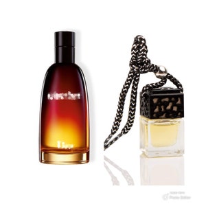 May include: A black and gold bottle of Dior Sauvage cologne with a matching car air freshener. The air freshener is hanging from a black string.