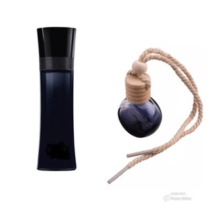 May include: A black glass bottle of perfume with a black cap and a dark blue liquid. Next to it is a small, round, glass bottle with a wooden cap and a dark blue liquid. The bottle is attached to a long, brown rope.