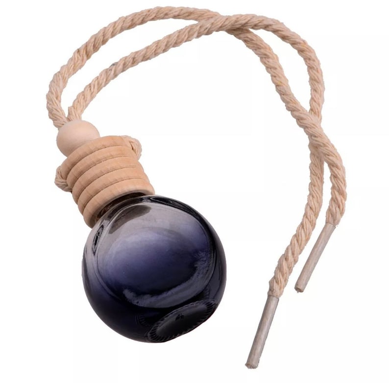 Op de afbeelding: Een donkerblauwe glazen aromatherapie-diffuser met een houten dop en een beige touw om op te hangen. De diffuser heeft een ronde vorm en is ontworpen voor etherische oli&euml;n. Het touw is gemaakt van een gedraaide natuurlijke vezel.