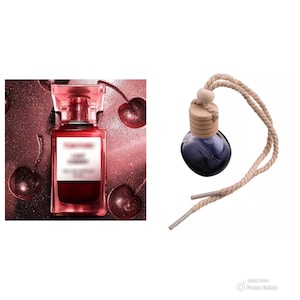 May include: A red glass bottle of perfume with a gold cap and a cherry design. The bottle is sitting on a red glitter background. A small blue glass bottle with a wooden cap and a brown rope is hanging from the top of the image.
