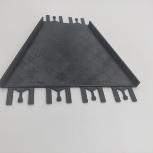 May include: Black plastic tile spacer with multiple slots for creating even grout lines.