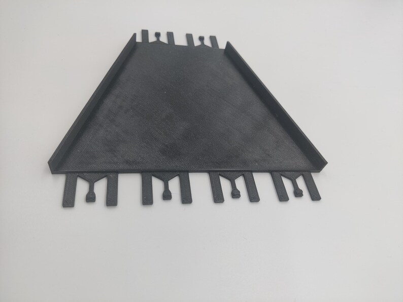 May include: Black plastic tile spacer with multiple slots for creating even grout lines.