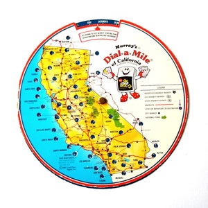 May include: A vintage, round, colorful map of California with the title "Murray's Dial-a-Mile of California" and a cartoon character holding a book labeled "The Map Box".