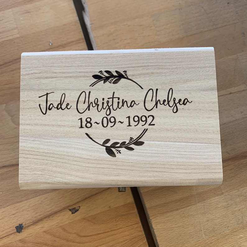 May include: A light wood box with a floral design and the text "Jade Christina Chelsea 18-09-1992" engraved on the lid.