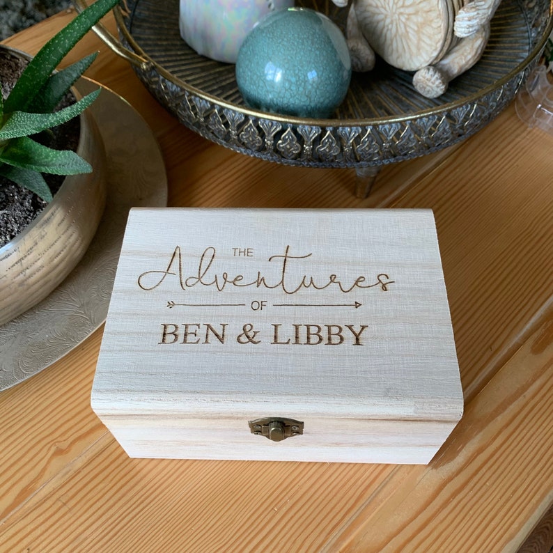 May include: A wooden box with a hinged lid and a brass latch. The box is engraved with the text "The Adventures of Ben & Libby".