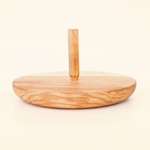 Op de afbeelding: Een houten dienblad met een ronde basis en een enkele houten handgreep in het midden.