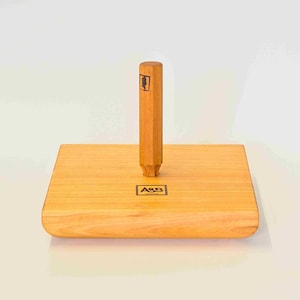 Peut inclure: Une base en bois avec un bord arrondi et un cheville en bois avec un dessus carré. La base porte l'inscription "A&S France".