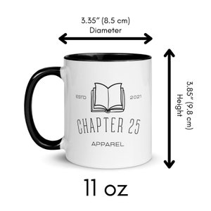 May include: White ceramic mug with a black rim and handle. The mug features a black and white illustration of an open book with the text "ESTD 2021 CHAPTER 25 APPAREL". The mug is 11 ounces and measures 3.35 inches in diameter and 3.85 inches in height.