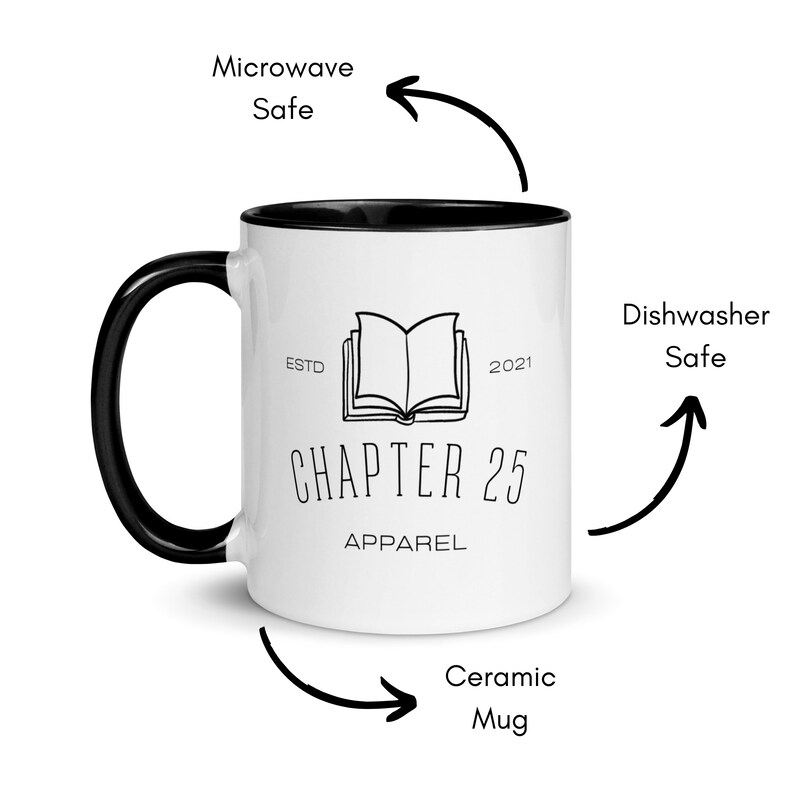 May include: White ceramic mug with a black rim and handle. The mug features a black and white illustration of an open book with the text "ESTD 2021 CHAPTER 25 APPAREL". The mug is microwave and dishwasher safe.
