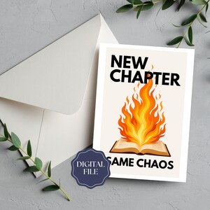 May include: A white greeting card with the text "NEW CHAPTER SAME CHAOS" above a burning book illustration. The card is set against a cream background, with a white envelope and a "DIGITAL FILE" sticker.