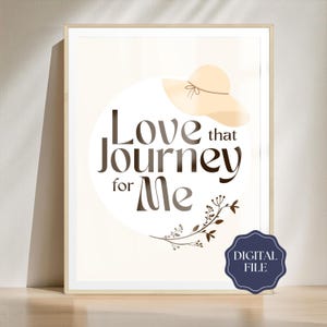 May include: A printable digital file featuring a beige hat with a brown ribbon and the text "Love that journey for me" in a brown font. The text is surrounded by a circle with a brown floral design.