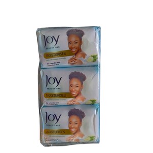 Puede incluir: Tres barras de jab&oacute;n Joy Beauty Bar envueltas. Cada barra presenta la imagen de una mujer y las palabras "Joy BEAUTY BAR MOISTURISES" con texto sobre nutrientes de leche y pepino. El jab&oacute;n est&aacute; dise&ntilde;ado para una piel m&aacute;s suave y tersa.